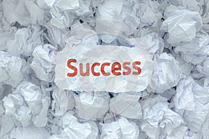 The word SUCCESS is placed on the background paper in the big trash