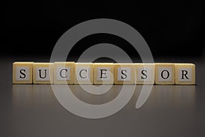The word SUCCESSOR written on wooden cubes isolated on a black background photo