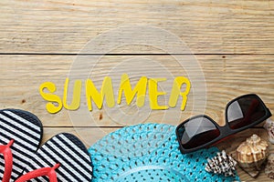 The word summer made of paper yellow letters and summer, beach accessories on a natural wooden background. summer. vacation. relax