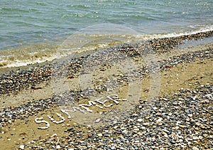 The Word Summer on a Pebbles Beach