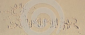 Word summer and shape of sun written on sand at beach. Travel and vacation time