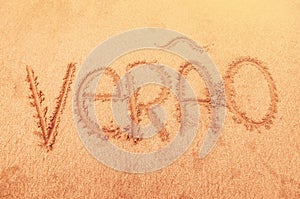 Word `summer` written in portuguese on sand