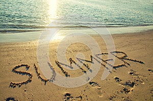 Word summer written on white sand beach. Summer holiday, travel and vacation concept. Abstract sea beach background