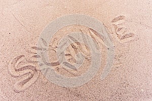 Word sun in german written on the sand of the beach