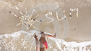 Word sun made of shells on a sandy beach