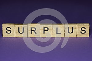 Word surplus in small wooden letters