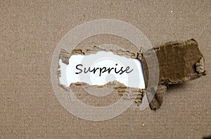The word surprise appearing behind torn paper