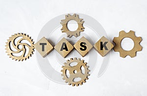 Word TASK made from letter blocks and cogwheels