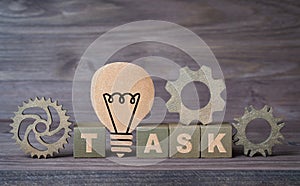 Word TASK made from wooden blocks with cogs