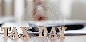 Word TAX DAY composed of wooden letters. Closeup photo