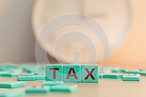 The word TAX made of small colorful game board pieces with letters imprinted on them. Financial research, government