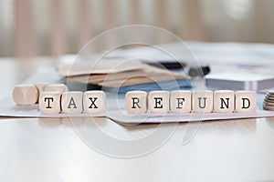 Word TAX REFUND is composed of wooden letters.