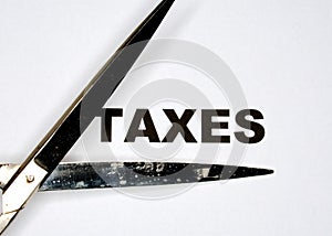 The word TAXES being cut by scissors