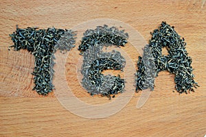 Word tea made from loose leaf tea on wooden background photo