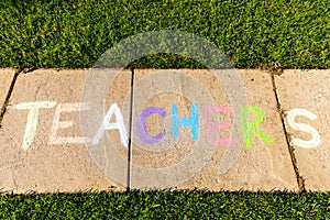 The word `Teachers` written with sidewalk chalk