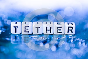 Word TETHER formed by alphabet blocks on mother cryptocurrency