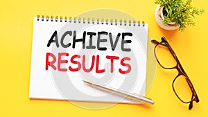 Word text ACHIEVE RESULTS on white paper card, business concept