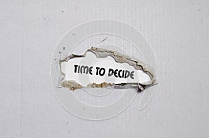 The word time to decide appearing behind torn paper