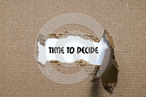 The word time to decide appearing behind torn paper