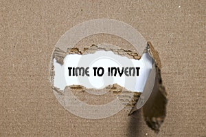 The word time to invent appearing behind torn paper