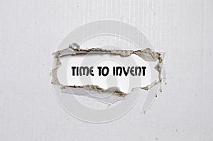 The word time to invent appearing behind torn paper