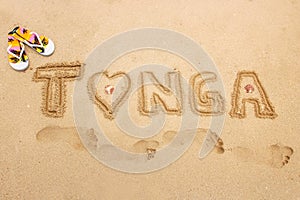 Word Tonga written in a sand