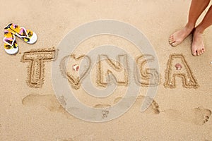 Word Tonga written in a sand