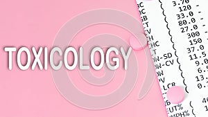 Word Toxicology on pink background, medical concept, top view