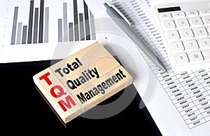 Word TQM made with wood building blocks, business concept