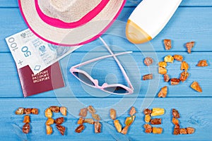 Word travel with shape of sun, sunglasses, sun lotion, straw hat, passport with polish money