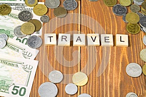Word TRAVEL on wooden cubes with money frame at wood background.Financial concept