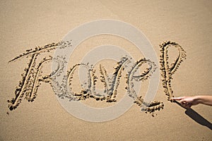 The word travel written in the sand