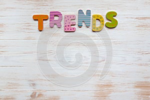 Word trend of colorful wooden letters on vintage white painted wood background. Top view, copy space. Trend concept