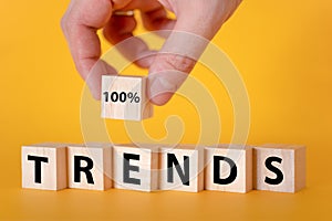 The word trend on wooden cubes, yellow background