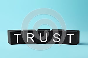 Word Trust made of black cubes on light blue background
