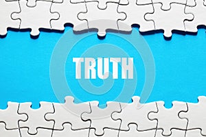 The word truth framed by jigsaw puzzle pieces. To discover or expose the truth, facts and reality