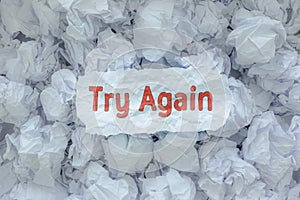 The word TRY AGAIN  is placed on the background paper in the big trash