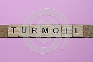 word turmoil from small gray wooden letters