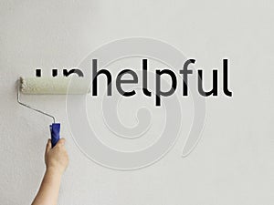 The word unhelpful is filled with white paint and becomes helpful photo