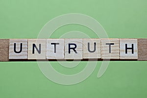 word untruth made of small gray wooden letters