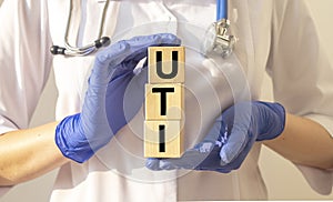 Word uti concept, urinary tract infection inscription on cubes in doctor hands