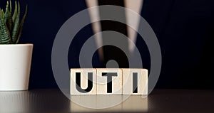 Word uti urinary tract infection on a wooden cubes on a blue background