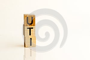 Word UTI - Urinary Tract Infection - on a wooden cubes on a white background