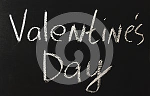 The word valentine`s day percent written in white chalk on a black chalkboard