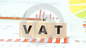 Word vat with letters on wooden cubes on desk with graphs