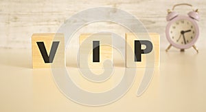 The word VIP consists of wooden cubes with letters, top view on a light background