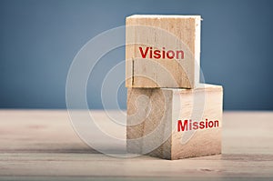 word VISION MISSION on wooden cube over gently lit dark background