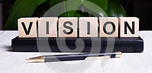 The word VISION is written on the wooden cubes of the diary near the handle