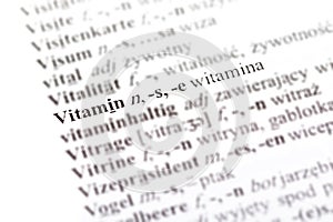 Word vitamin - witamina in a Polish - German dictionary line pointed out, selective focus, macro, closeup, detail, medicine