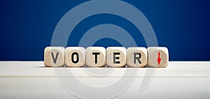 The word voter with downward arrow on wooden cubes. Elections and decreasing voter turnout